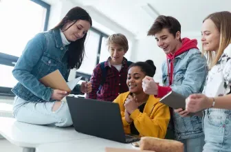 High school students working together around a computer