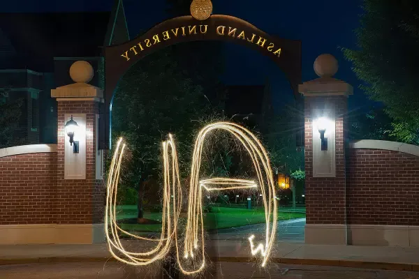 AU spelled out with sparkler in front of arch